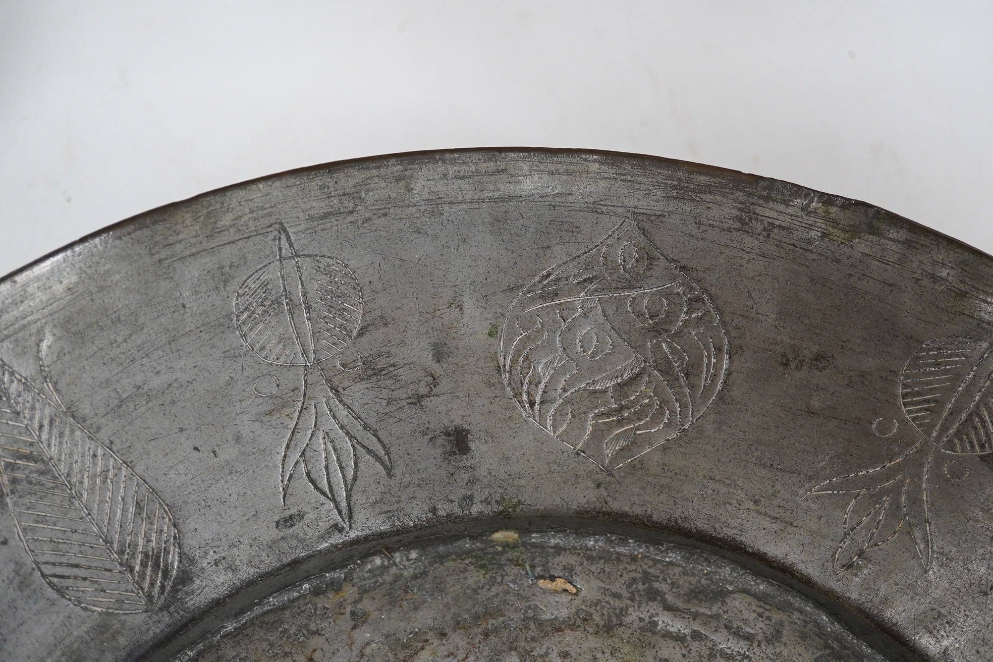 A n18th century style Dutch embossed brass oval jardiniere and a circular metal engraved plaque, jardiniere approximately 40cm wide (2). Condition - plaque rusty at centre, jardiniere fair